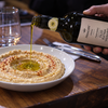 Bowl of hummus finished with a drizzle of Italian extra virgin olive oil in a UAE restaurant kitchen