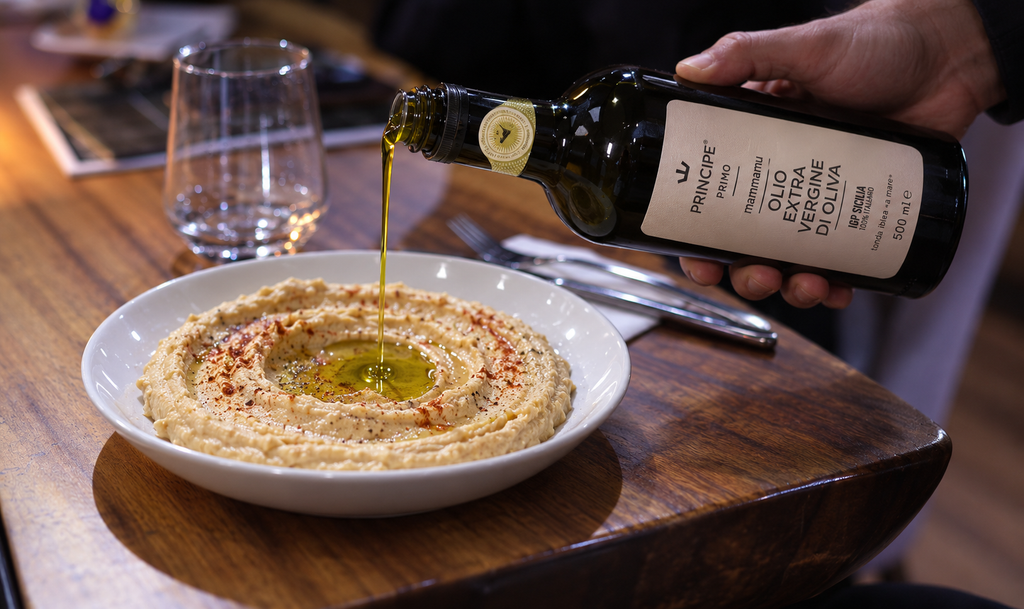 Bowl of hummus finished with a drizzle of Italian extra virgin olive oil in a UAE restaurant kitchen